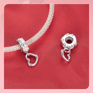 Macro detail of S925 sterling silver heart charm on mesh bracelet with hallmark