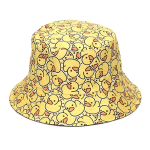 Close-up detail of yellow bucket hat featuring cute cartoon duck patterns and stitching