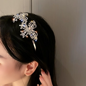 Close-up of sparkling silver butterfly headband with rhinestones on black hair