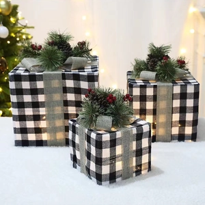 Détail de boîtes cadeaux de Noël à carreaux avec lumières LED et pommes de pin