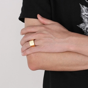 Close-up of a gold square ring with a hammered texture finish on a male model's finger