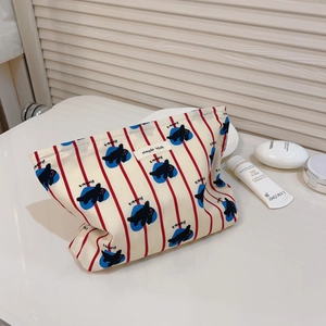 Détail de la trousse de maquillage en coton avec rayures rouges, pois bleus et lapin