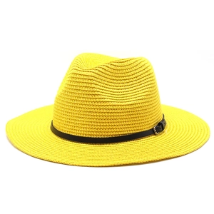 Close-up of bright yellow straw sun hat showing fine weave texture and black leather strap