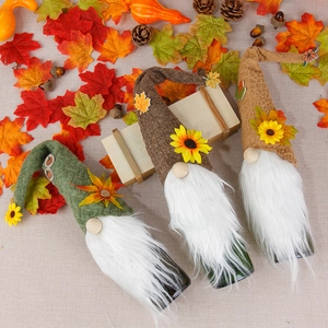 Three autumn gnome wine bottle covers with sunflowers, maple leaves and acorns