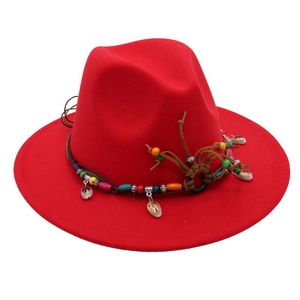 Close-up of red wool fedora with woven leather cord, wooden beads and shell accents