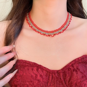 Detail view of handmade beaded necklace with red and silver crystal lace pattern