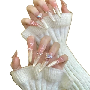 Long stiletto press-on nails with champagne cat eye effect and 3D bow heart charms