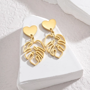 18K gold stainless steel heart and hollow monstera leaf earrings on white stone