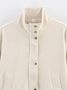 Detail of beige faux suede jacket featuring standing collar and round gold buttons