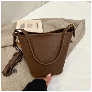 Detail of dark brown bucket bag with lychee pattern and embossed ZSRE logo branding