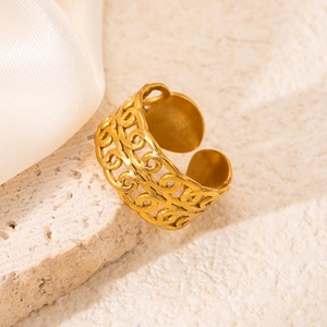 Detail of 18K gold plated open ring with intricate filigree on a textured stone