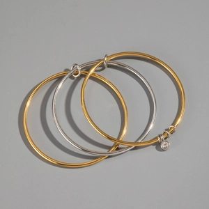 Three-piece layered gold and silver bracelets with a round cubic zirconia charm