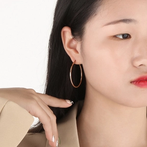 Rose gold stainless steel hoop earring shown on model for size and style reference
