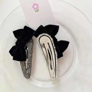 Luxurious velvet bow hair clips with rhinestones shown on a white display plate