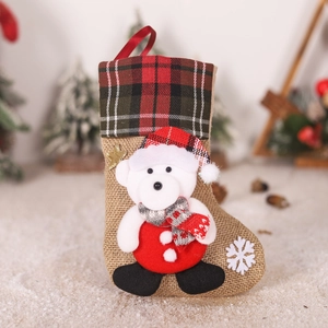 Detail of burlap Christmas stocking featuring 3D plush bear and festive plaid cuff