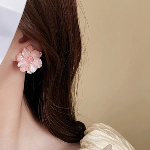 Élégantes boucles d'oreilles fleur rose en acrylique et perles sur l'oreille