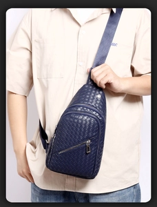 Detail of blue woven leather sling bag with multiple zipper pockets and adjustable strap