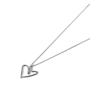 Detail shot of irregular heart pendant and fine link chain in polished silver finish