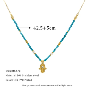 Nahaufnahme des 18K vergoldeten Hamsa-Hand-Anhängers mit blauen Chalcedon-Perlen auf Edelstahl