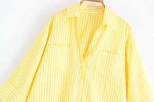 Detailed view of yellow and white striped shirt with two front pockets and collar