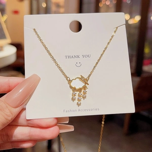 Detail of gold cloud pendant with zircon tassels and crown on a fine chain necklace