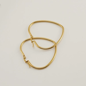 Detailed close-up of chunky gold-plated stainless steel heart-shaped hoop earrings