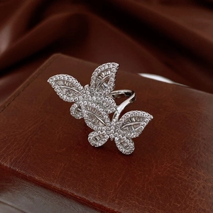 Macro shot of silver butterfly open ring with sparkling cubic zirconia on a leather case
