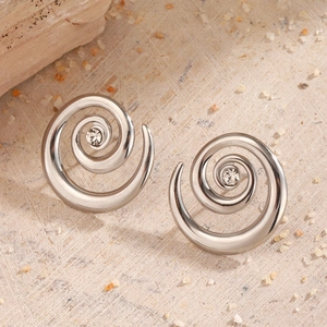 Minimalist silver stainless steel spiral earrings with center crystals on wood texture