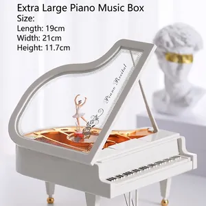 Close-up of white piano music box with golden interior and a ballet dancer figurine