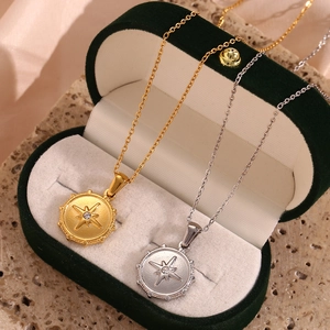 Close-up of gold and silver north star pendant necklaces in a velvet jewelry box