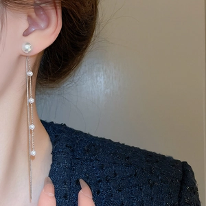 Elegant long pearl tassel earrings featuring S925 silver needles worn on a model's ear