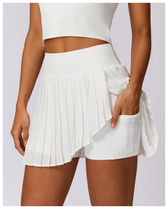 Gros plan sur jupe de sport plissée blanche montrant le short intégré et la poche latérale