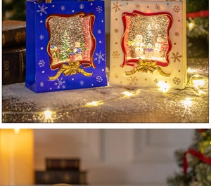 Close-up of blue and white Christmas lantern music boxes with warm LED lights and snow scene