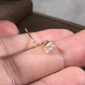 Orecchino a catena in oro minimalista con pendente in zirconia scintillante in mano