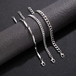 Detail of silver Figaro, Cuban, and curb chains on a textured dark leather stand