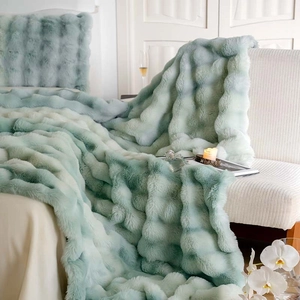 Detail showing the plush faux rabbit fur texture and 3D grid pattern of the green blanket