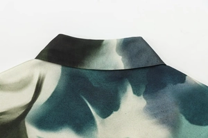 Détail du col à revers avec imprimé lavis d'encre vert et sarcelle sur texture de soie