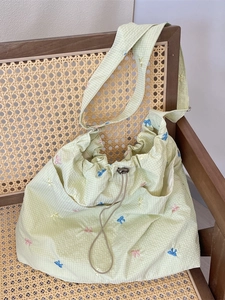Borsa tote in tela a quadretti verde chiaro con ricami di farfalle colorate su sedia