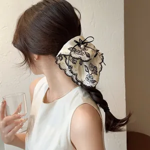 Elegant beige rose print hair scrunchie with black lace trim and pearl accent for women