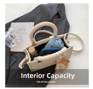 Internal capacity of minimalist bucket bag with phone, umbrella, and horse charm