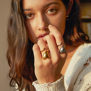 Polished 18k gold and silver heart-shaped open rings worn as a stylish minimalist set