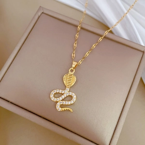 Luxurious gold cobra pendant necklace with sparkling zircon pavé on a jewelry box