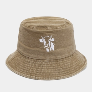 Detailed macro view of khaki washed cotton bucket hat with white cow embroidery