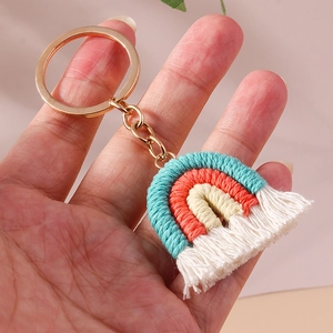 Detail of handmade bohemian woven rainbow keychain with soft cotton tassels and gold ring