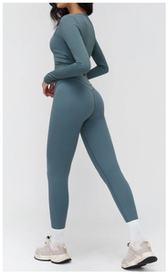 Détail du haut de yoga à manches longues ajusté avec col en V en tissu technique bleu brume