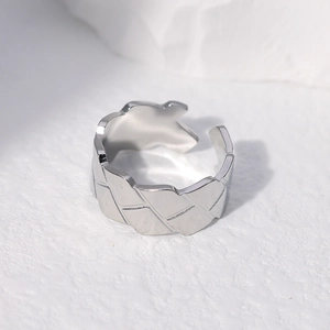 Macro view of adjustable stainless steel ring with engraved geometric leaf-like texture