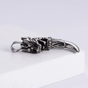Macro shot of retro silver dragon head claw pendant with intricate scale carving