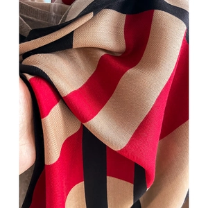 Macro view of herringbone weave texture and geometric color-block patterns on soft scarf