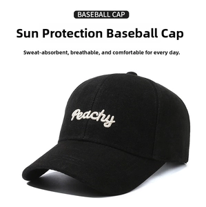 Detailed view of Peachy white script embroidery on a black cotton baseball cap fabric