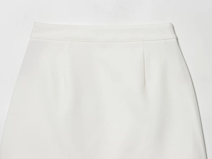 Detailed view of high-waisted white mini skirt featuring a clean waistline and sleek seams